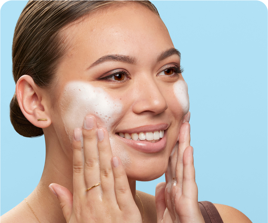  Smiling woman applying Olay foaming cleanser for deep skin cleansing and barrier support