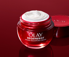 Brilliant red glass jar of Olay Micro-Sculpting Cream Moisturizer on a deep red background with its lid removed to display its smooth cream texture