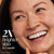 Model posing smiling. 2x brighter skin in 1 month* *Vs a basic moisturizer.