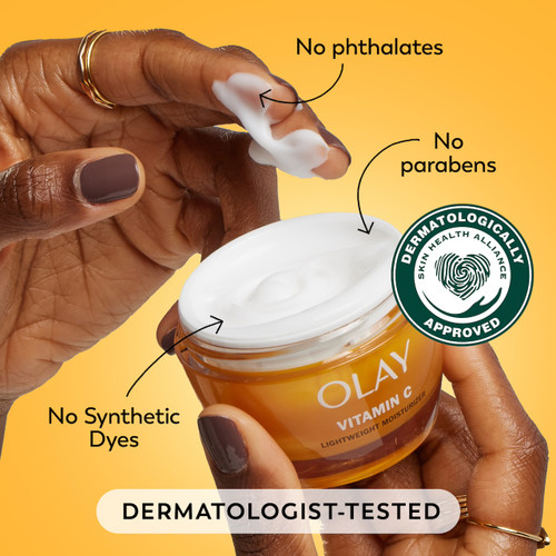 Model dipping fingers in Vitamin C moisturizer. No phthalates, no parabens, no synthetic dyes. Dermatologist tested. Dermatologically approved.