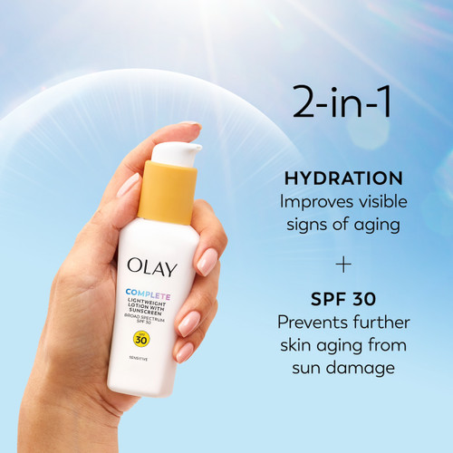 Model holding Olay Complete Lotion Moisturizer with SPF 30 Sensitive in hand. 2 in 1 hydration improves visible signs of aging. SPF 30 prevents further skin aging from sun damage.