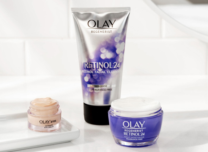 'The Anti-Wrinkle Set' on a white, minimalist bathroom counter. The set features one Olay Retinol 24 Facial Cleanser, one jar of Olay Retinol 24 Moisturizer, and one Olay Eyes Ultimate Eye Cream
